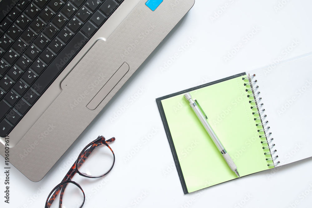 Laptop computer, eyewear and notebook with pen, Workplace on white background Laptop computer, eyewear and notebook with pen, Workplace on white background
