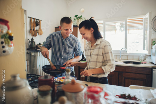 Romantic couple in love spending time together in kitchen