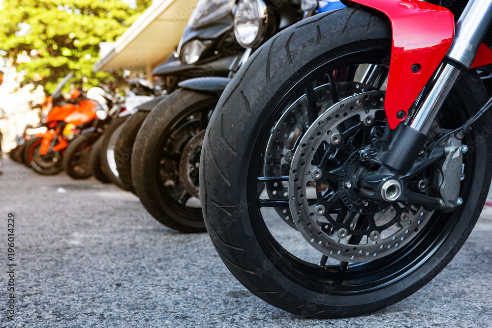 Obraz premium Motocyklowe przednie koło z czerwoną błotnikiem i podwójnym hamulcem tarczowym