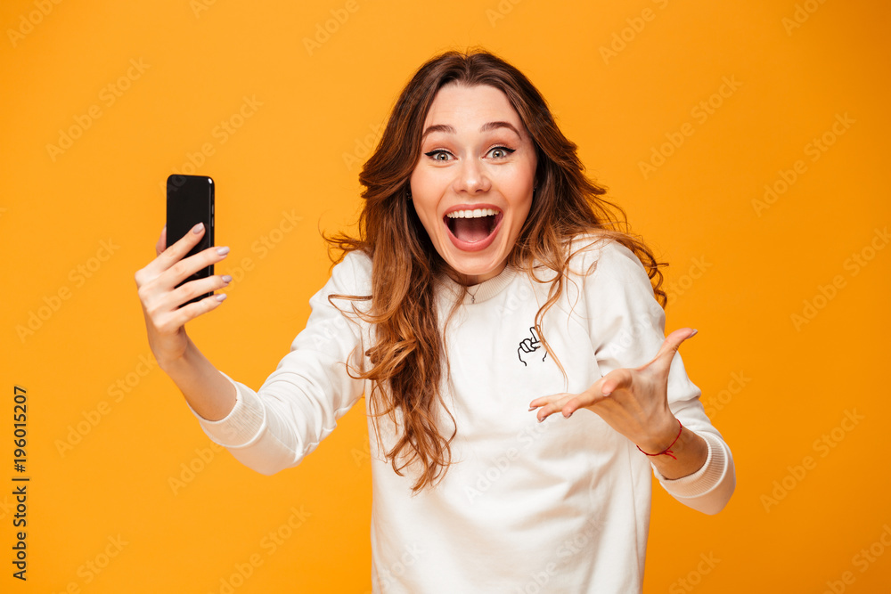 Surprised happy brunette woman in sweater holding smartphone Surprised happy brunette woman in sweater holding smartphone