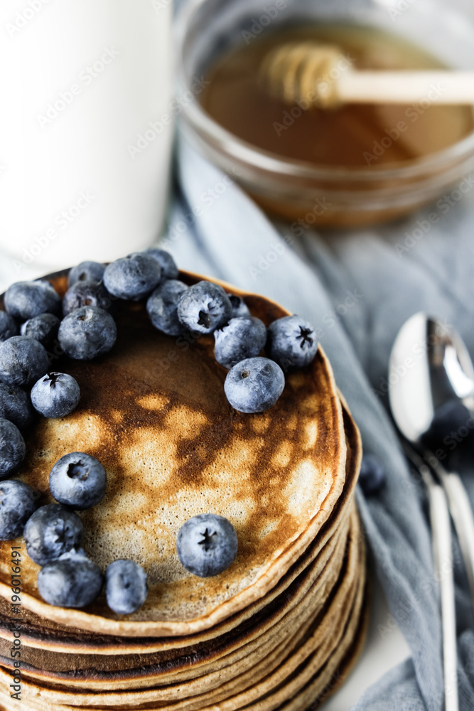 Homemade Chocolate Pancake with blueberries on a concrete gray background with milk and honey. Food photography of a healthy morning breakfast. Gauze Fabric. Homemade Chocolate Pancake with blueberries on a concrete gray background with milk and honey. Food photography of a healthy morning breakfast. Gauze Fabric.