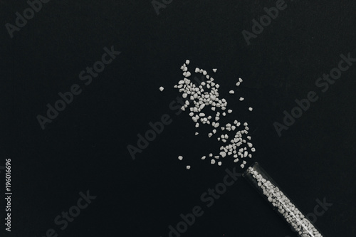 Scattered flavored salt on black background