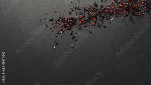 Scattered red spice on black background