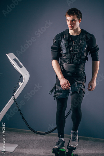 Caucasian man training on stepper with electric muscle stimulation photo