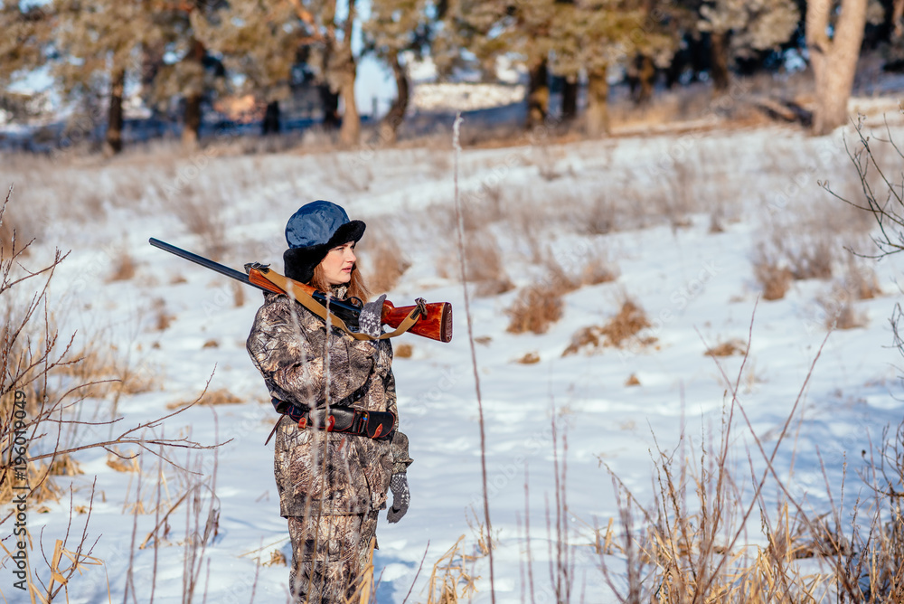 female hunter in camouflage clothes ready to hunt, holding gun and walking in forest. hunting and people concept female hunter in camouflage clothes ready to hunt, holding gun and walking in forest. hunting and people concept