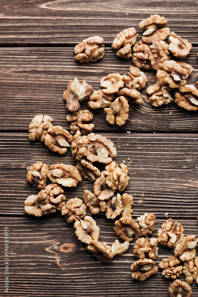 Pile of shelled walnuts on wooden background, healthy eating concept Pile of shelled walnuts on wooden background, healthy eating concept