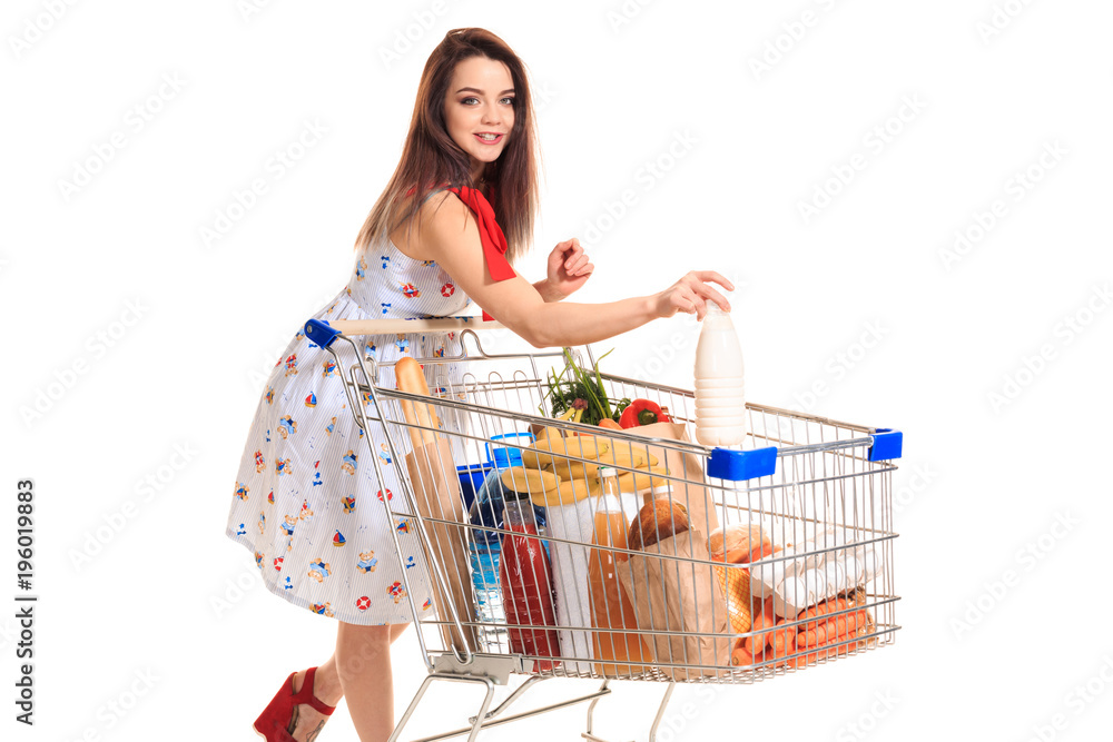 Φωτογραφία Smiling young woman doing grocery shopping at the supermarket, she is putting a