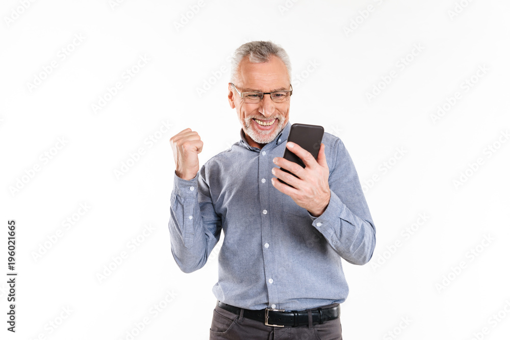 Happy man using smartphone and making winner gesture Happy man using smartphone and making winner gesture