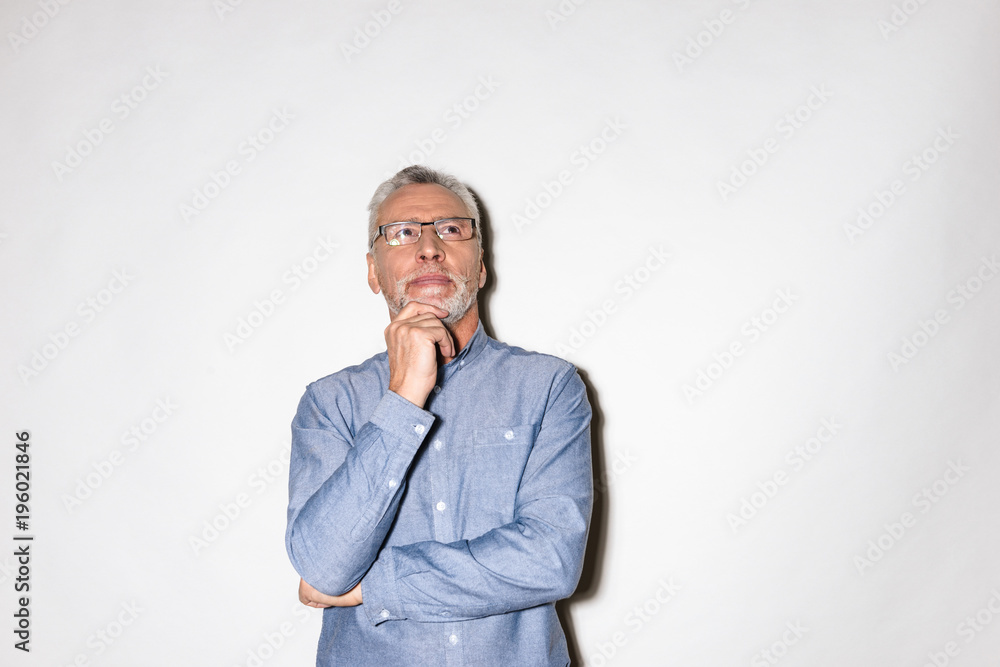Thoughtful man looking up at copy space and thinking isolated Thoughtful man looking up at copy space and thinking isolated