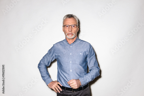 Serious man in blue shirt looking camera isolated photo