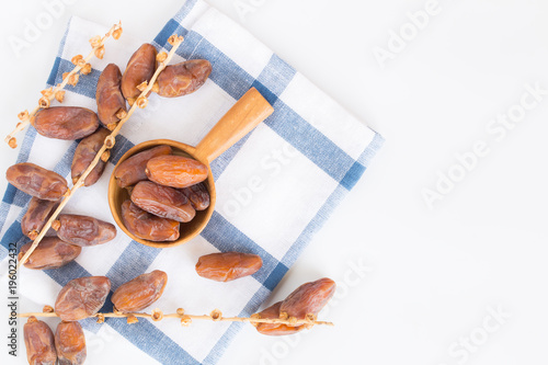 Dates fruit in wooden ladle on white background,Dried date palm fruits top view photo