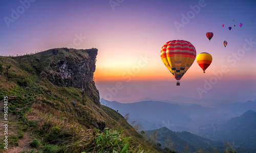 Colorful hot air balloons flying over mountain at Phu Chi fa National Park in the morning. Chiang Rai Province, Thailand photo