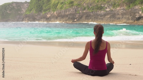 Woman meditates in yoga asana Padmasana