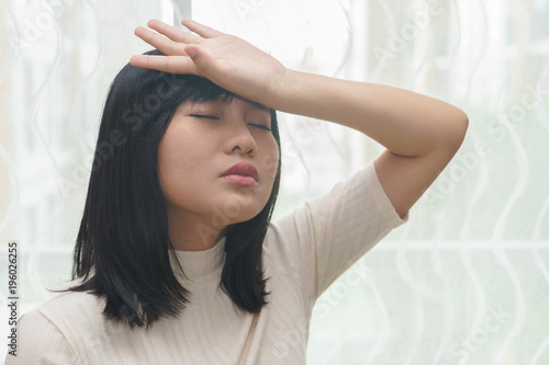 Woman with headache or cold in her room - health concept.