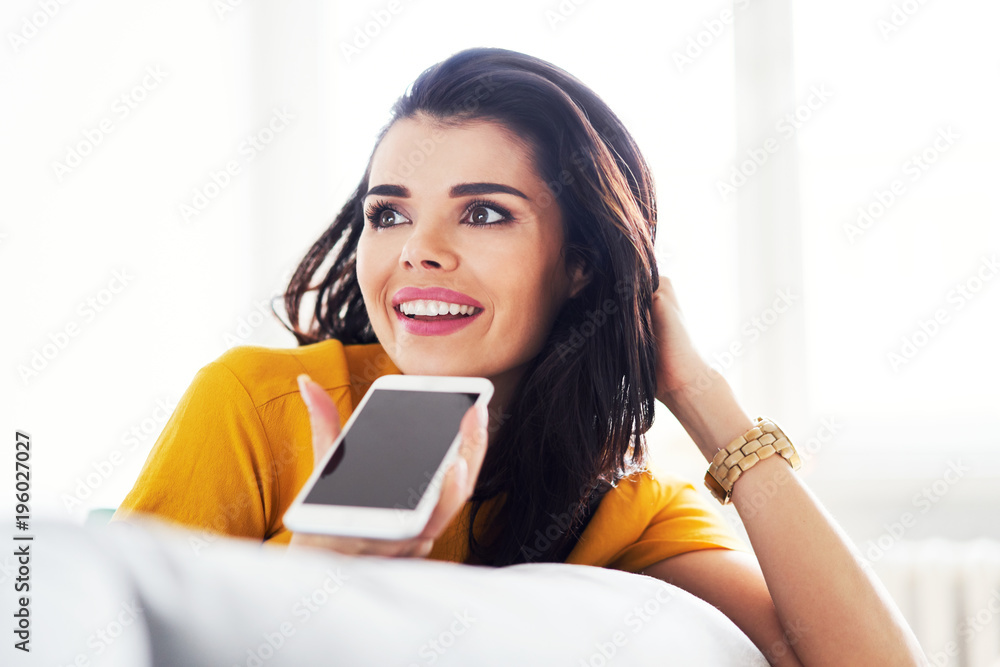 Young woman talking on phone on speaker mode and looking away Young woman talking on phone on speaker mode and looking away