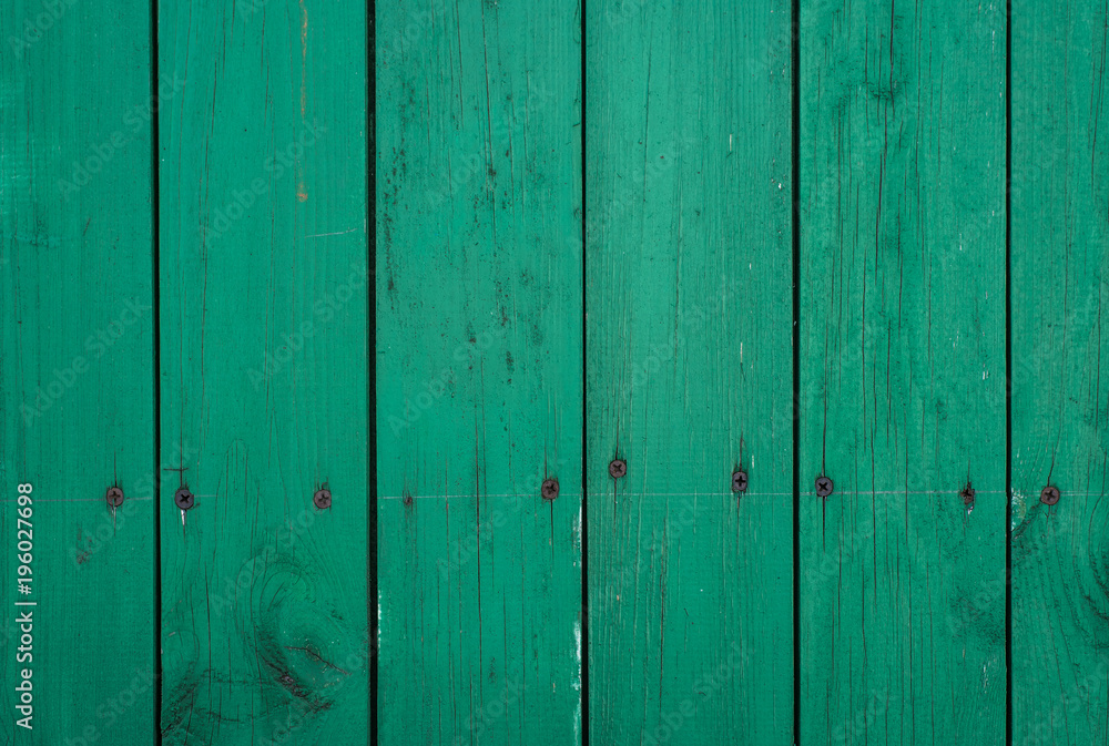 Naklejka premium Green wooden board with nails - wooden background