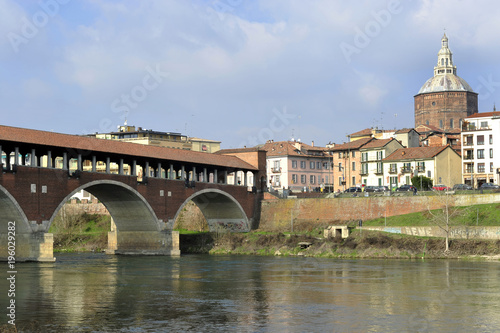 Italy - Pavia - The Covered Bridge (also called Ponte Vecchio) on the ticino with the Cathedral of the city in the background