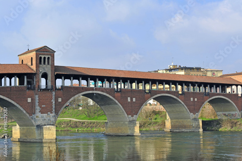 Italy - Pavia - The Covered Bridge (also called Ponte Vecchio) on the ticino with the Cathedral of the city in the background