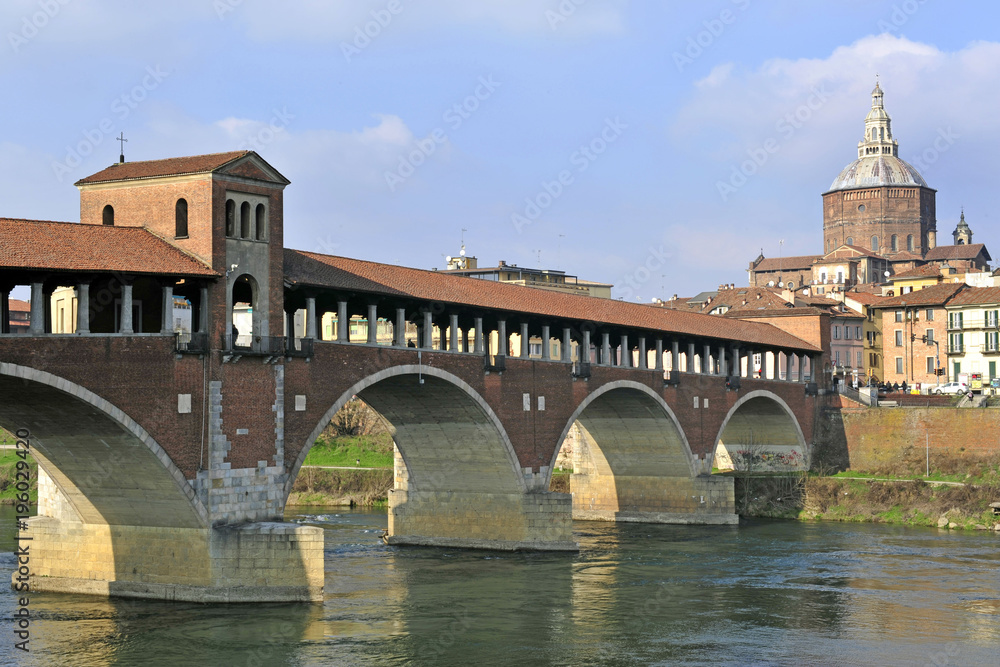 Italy - Pavia - The Covered Bridge (also called Ponte Vecchio) on the ticino with the Cathedral of the city in the background