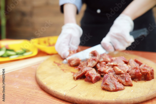 The cook cuts meat for cooking barbecue