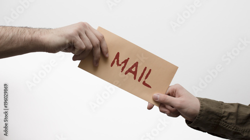 Two men hands receiveng and giving mail in envelope on the white background. Mailtime concept
