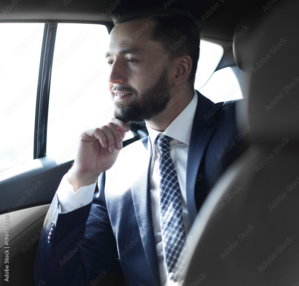 Smiling business man sitting in the back seat of a car Smiling business man sitting in the back seat of a car