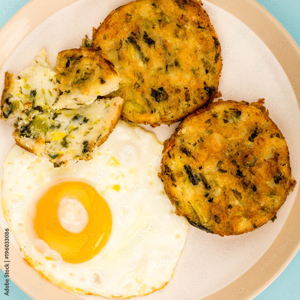 Fototapeta premium Cooked Vegetarian Bubble And Squeak Cakes With A Fried Egg