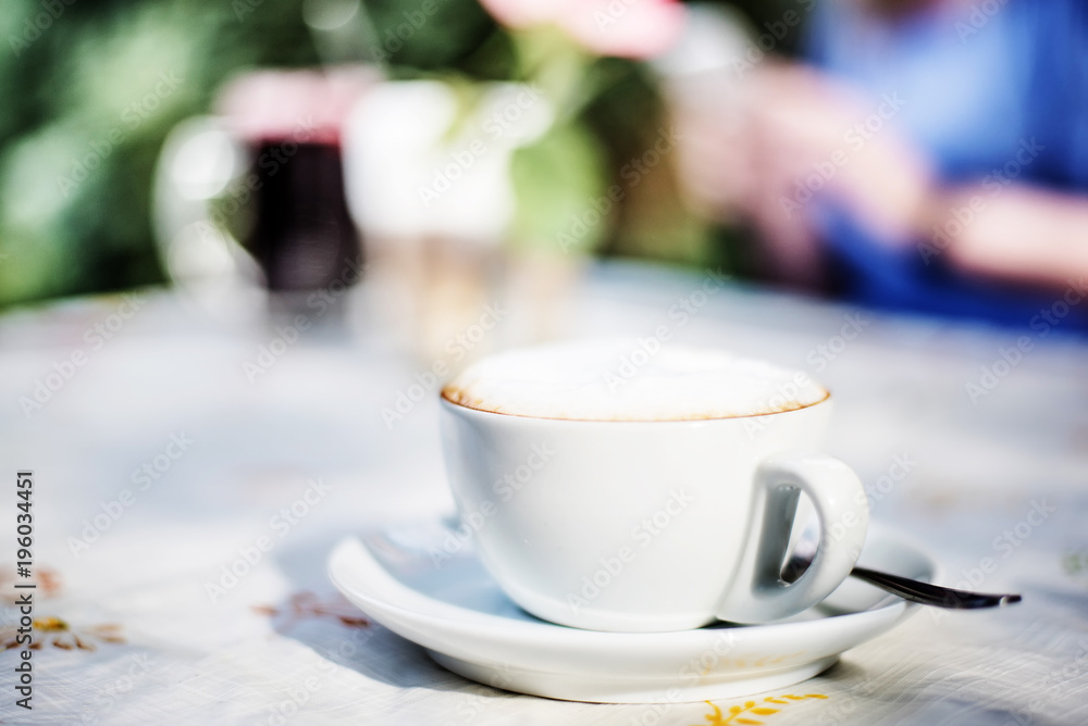 cup of cappuccino on table in outdoor setting