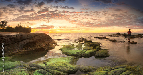Stitched Panorama of sunset at the beach with natural coastal rocks. nature composition. © udoikel09