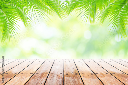 Empty wooden table with party in coconut leafs in resort garden background blurred.