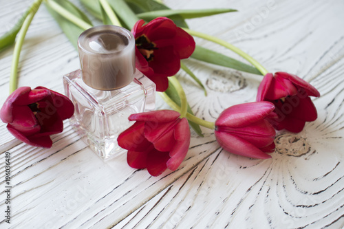 women's perfume and tulips on a wooden table photo