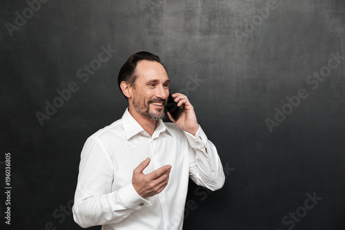 Portrait of a happy mature man dressed in shirt talking