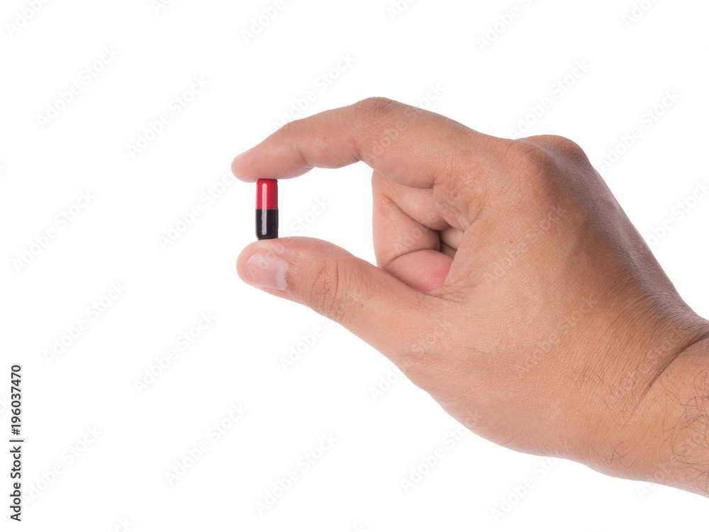 Hand holding a capsule or pill isolated on white. Hand holding a capsule or pill isolated on white.