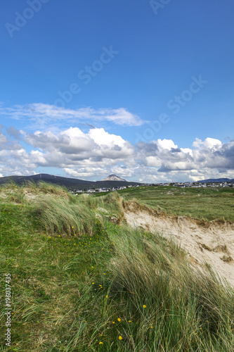 Ireland sea coast with the village and big mountain in the background