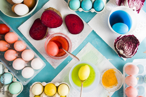 Dyeing eggs for Easter holidays, coloring with different red  color and tonality using food colorant over a gray concrete background