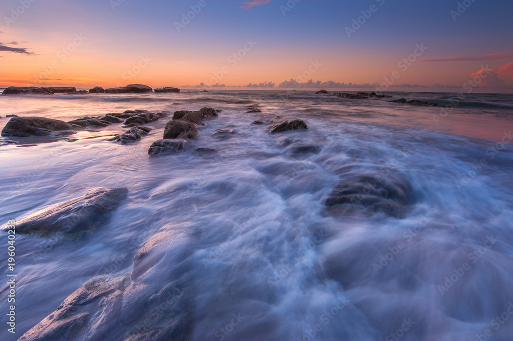 view of seascape during sunset with waves trails.