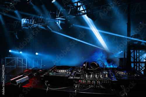 DJ console in the atmosphere of the party, light spotlights. Scene fragment