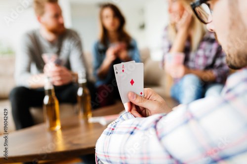 Group of friends having fun while playing cards photo