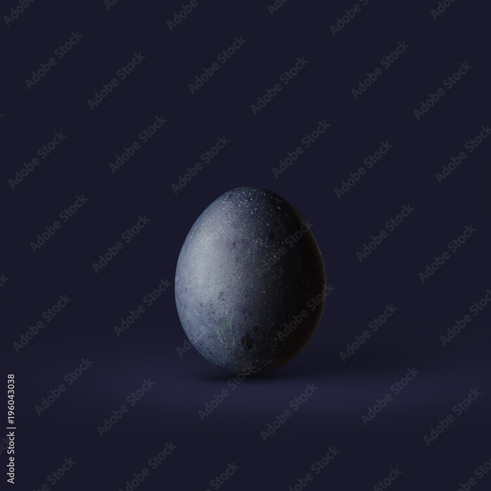 Dark blue easter egg isolated on dark background Dark blue easter egg isolated on dark background