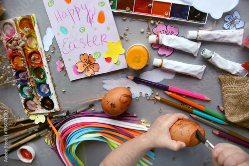 Fotografía A child paints Easter eggs. Easter composition