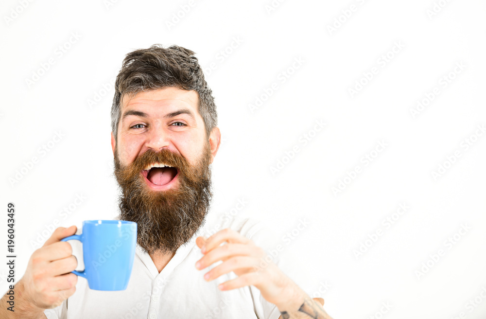 Hipster with beard holds mug. Man with happy face