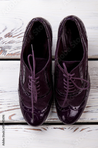 Purple women's shoes, flat lay. Close up shiny feminine shoes with shoelaces.