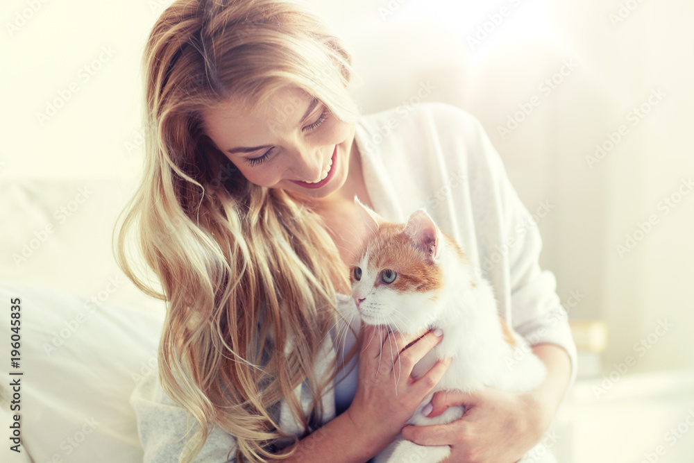 happy young woman with cat in bed at home happy young woman with cat in bed at home