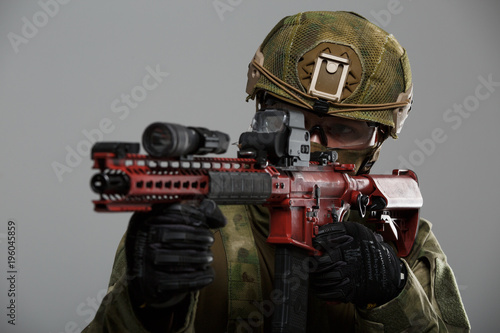 Photo of aiming military man in helmet with gun