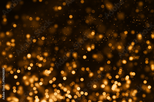 christmas gold gradient sparkle glitter dust particles from top on black background with bokeh flowing movement, golden holiday happy new year and valentine day love, relationship concept