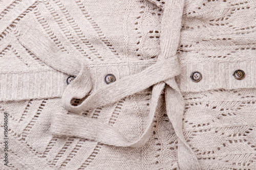 Texture of beige woolen clothing. Close up woolen cloth material with buttons. photo