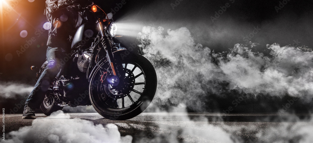 Fototapeta premium Close-up z siekacza motocyklowego wysokiej mocy z jeźdźca człowieka w nocy