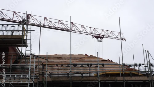Wallpaper Mural A crane operates in a construction site on a dim afternoon. Low angle shot. Torontodigital.ca