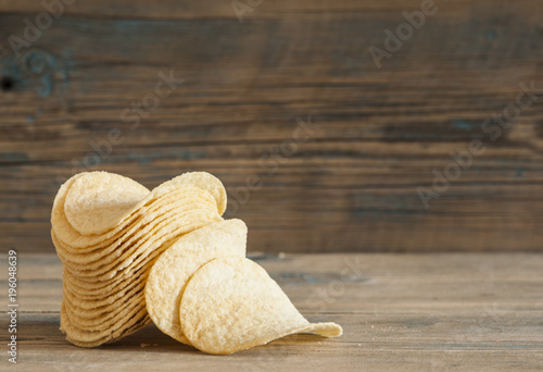 Golden natural potato chips on an old wooden table