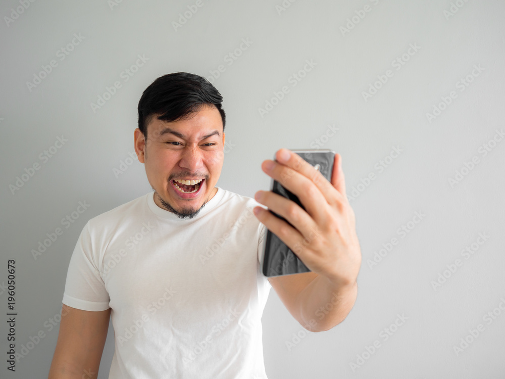 Funny laugh face of man watching funny video clip share in social in the smartphone. Funny laugh face of man watching funny video clip share in social in the smartphone.